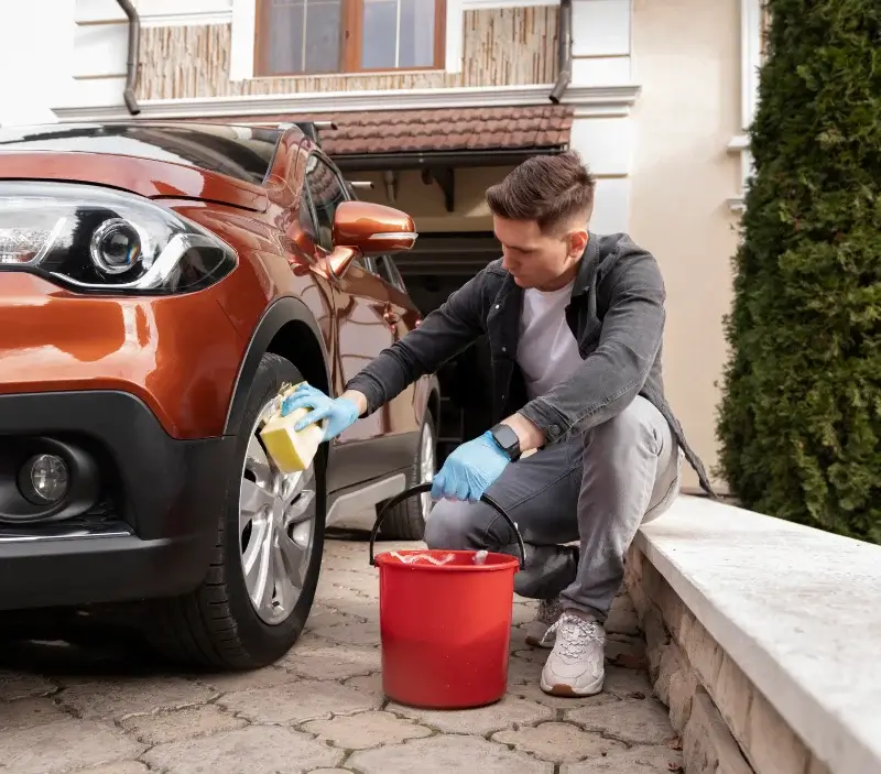 Lavage auto à domicile Le Mesnil-Guillaume : professionnel intervenant sur un véhicule
